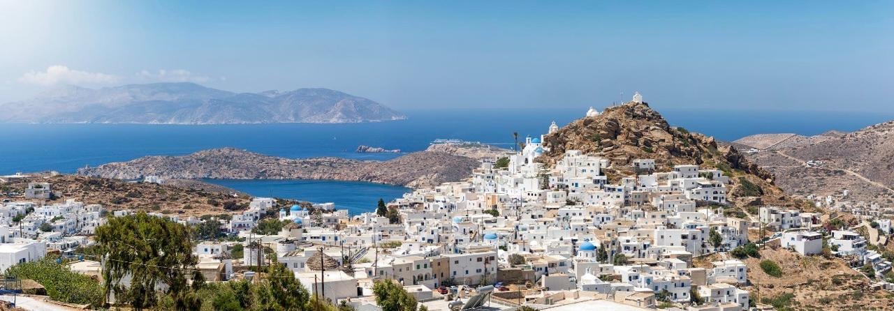 Whitewashed Chora tumbling down its hillside above the bay and islets of Ios